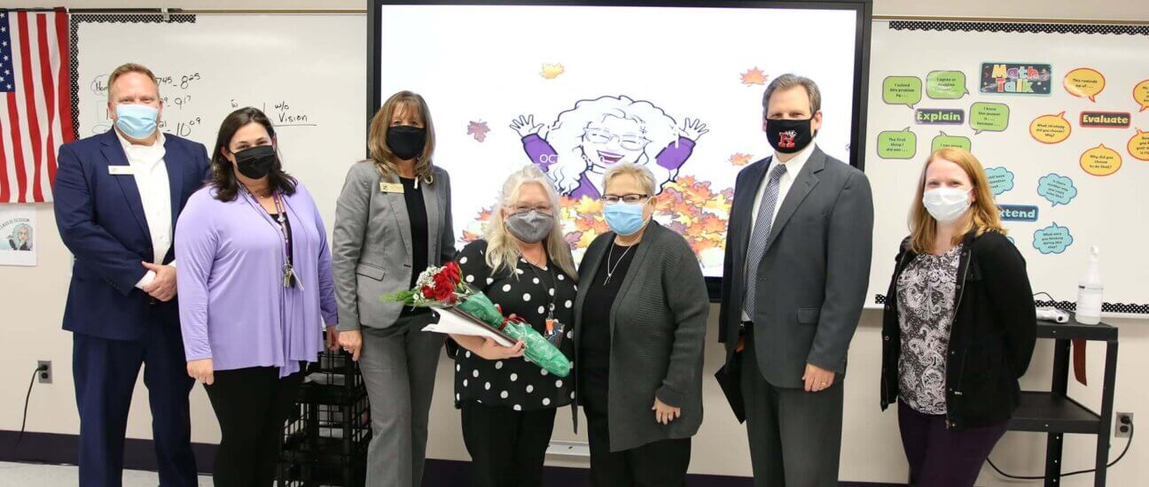 Educators standing by a interactive flat panel