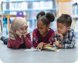 Diverse group of children reading a book together