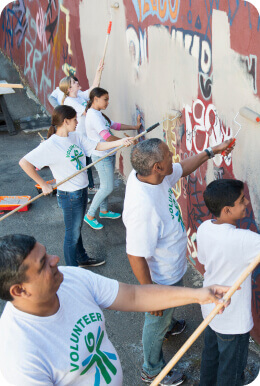 group of people painting over graffiti