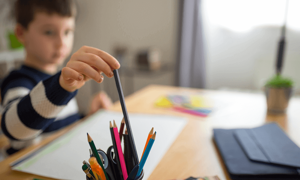 student reaching for pencil