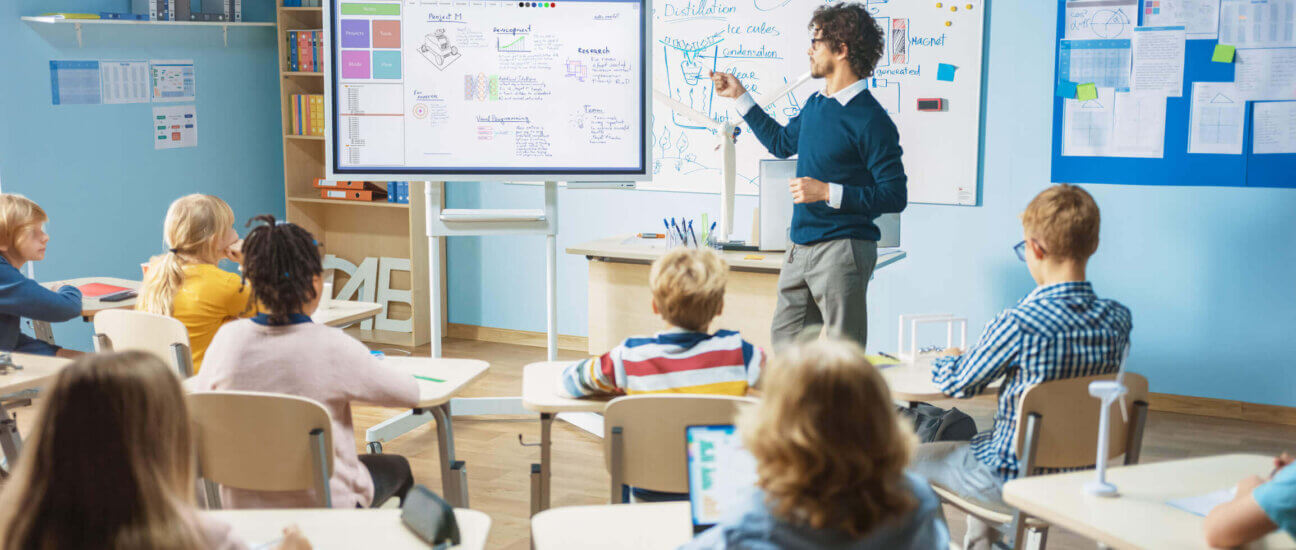 Teacher uses interactive whiteboard to engage students in lesson