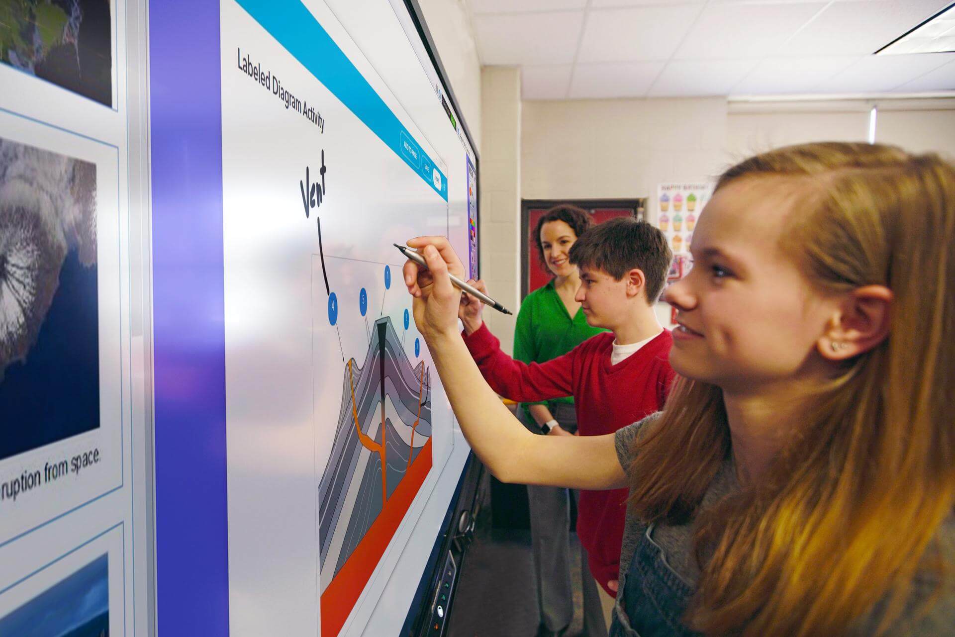 Dos alumnos utilizan simultáneamente una pantalla interactiva táctil 