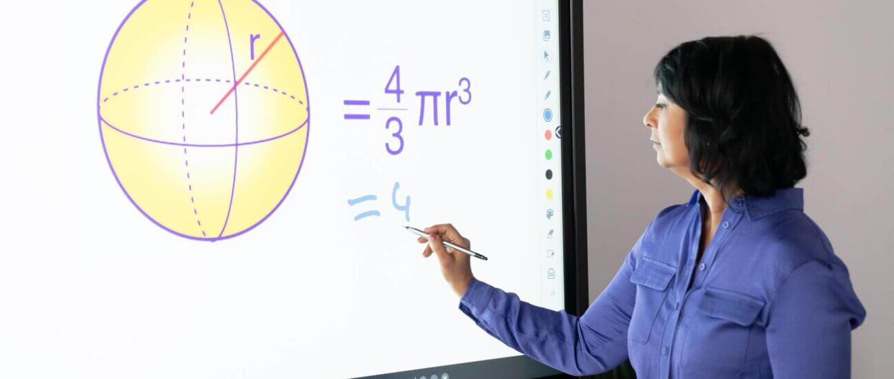 teacher using a math app on an interactive whiteboard in the classroom