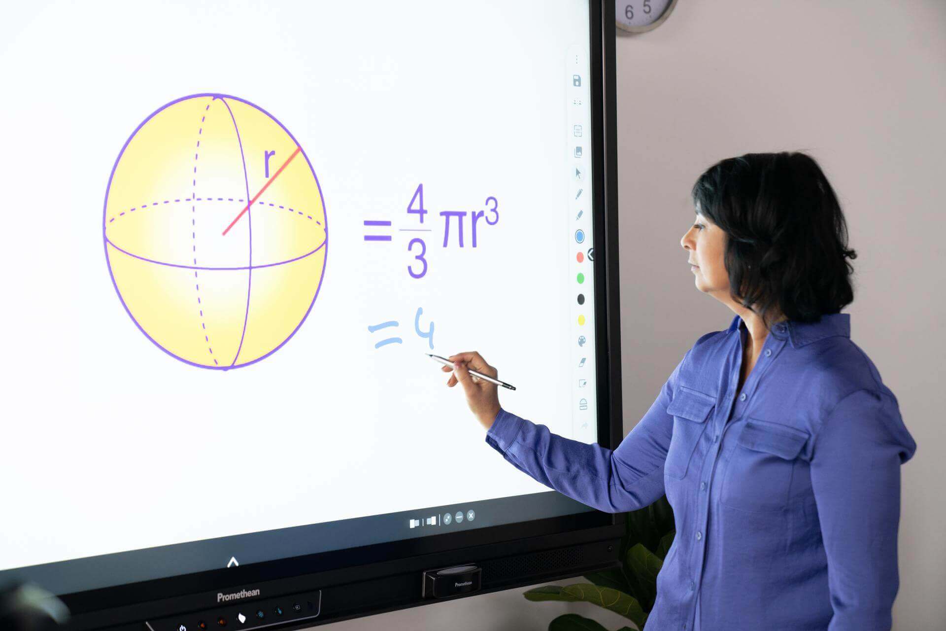 teacher using a math app on an interactive whiteboard in the classroom