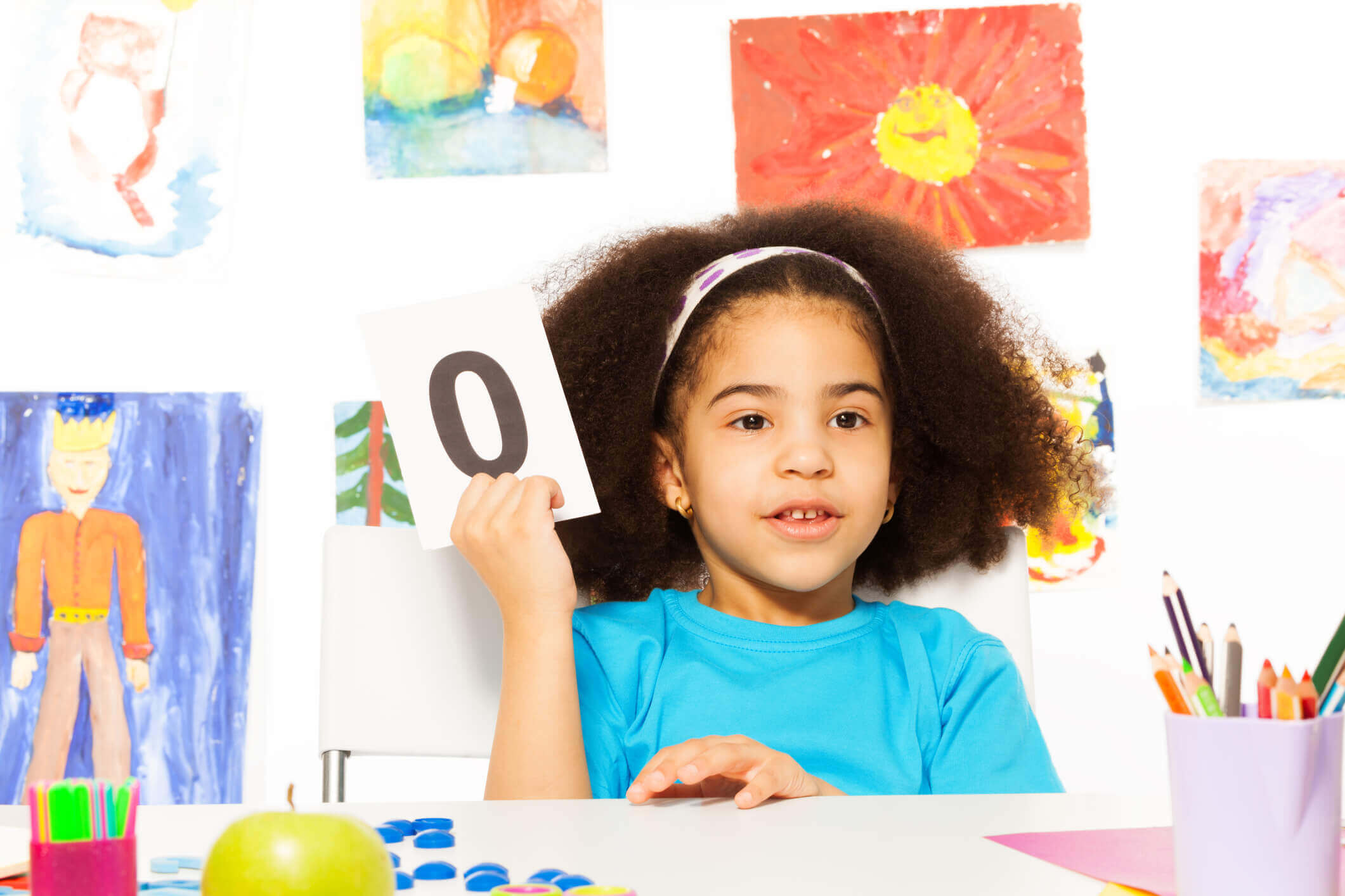 young student holding up flashcards in the classroom