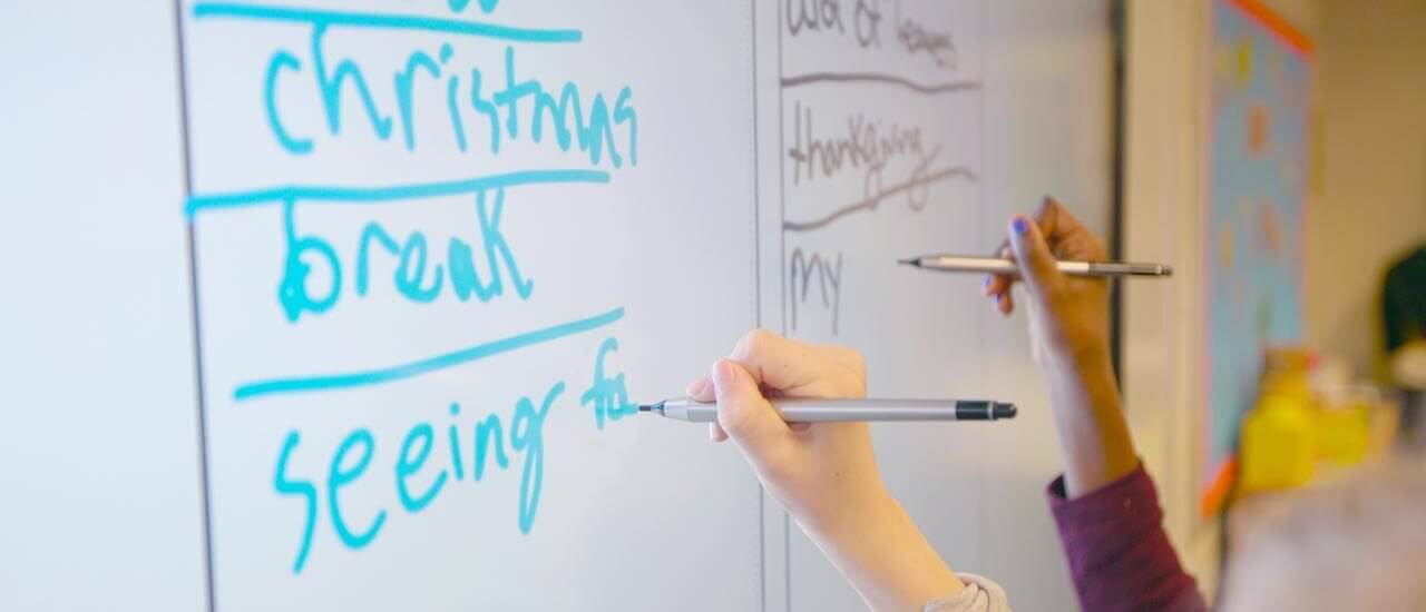 students using an interactive whiteboard for their English lesson in the classroom