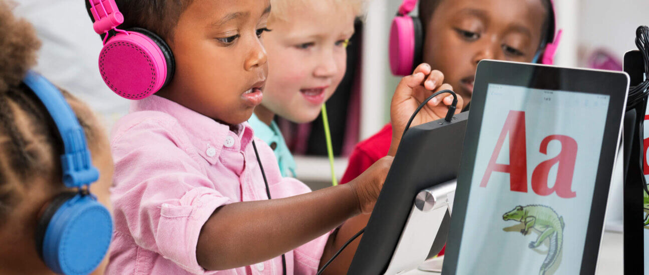 students working on phonics lessons in the classroom on tablets