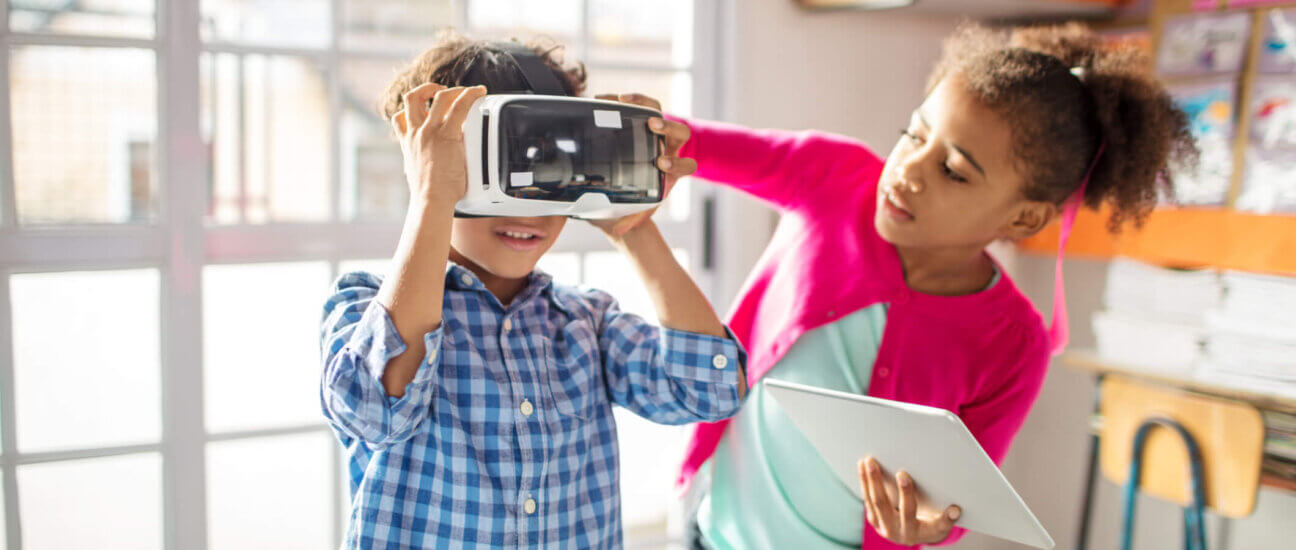 Deux élèves travaillent ensemble en utilisant un casque pour la réalité virtuelle et une tablette pour la réalité augmentée.