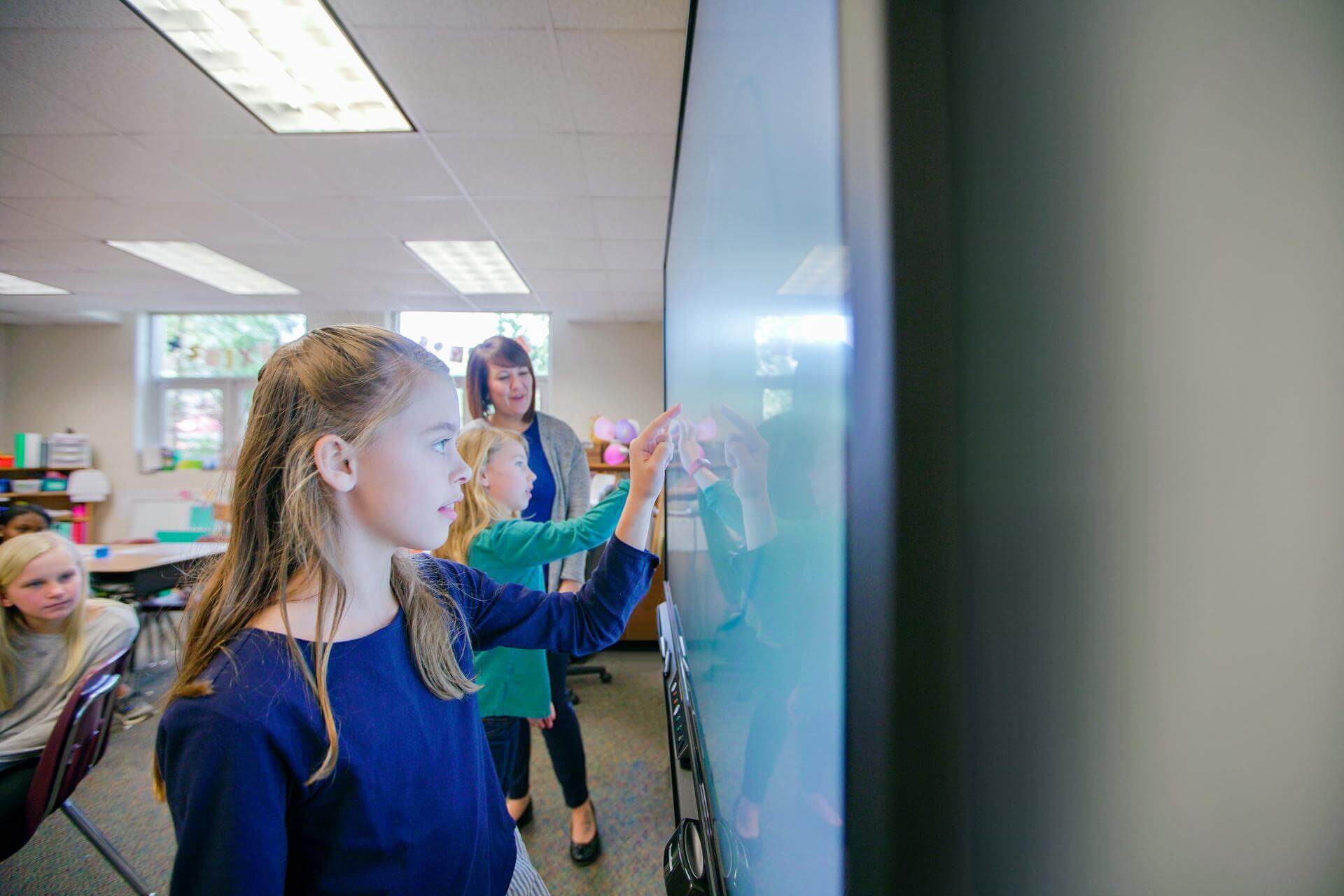 Niñas compiten usando un panel interactivo