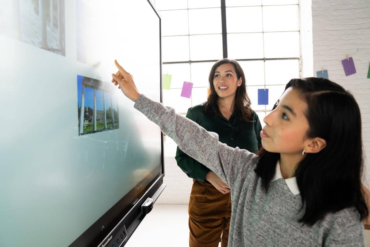 Une étudiante fait une présentation d’histoire sur un écran numérique interactif Promethean.