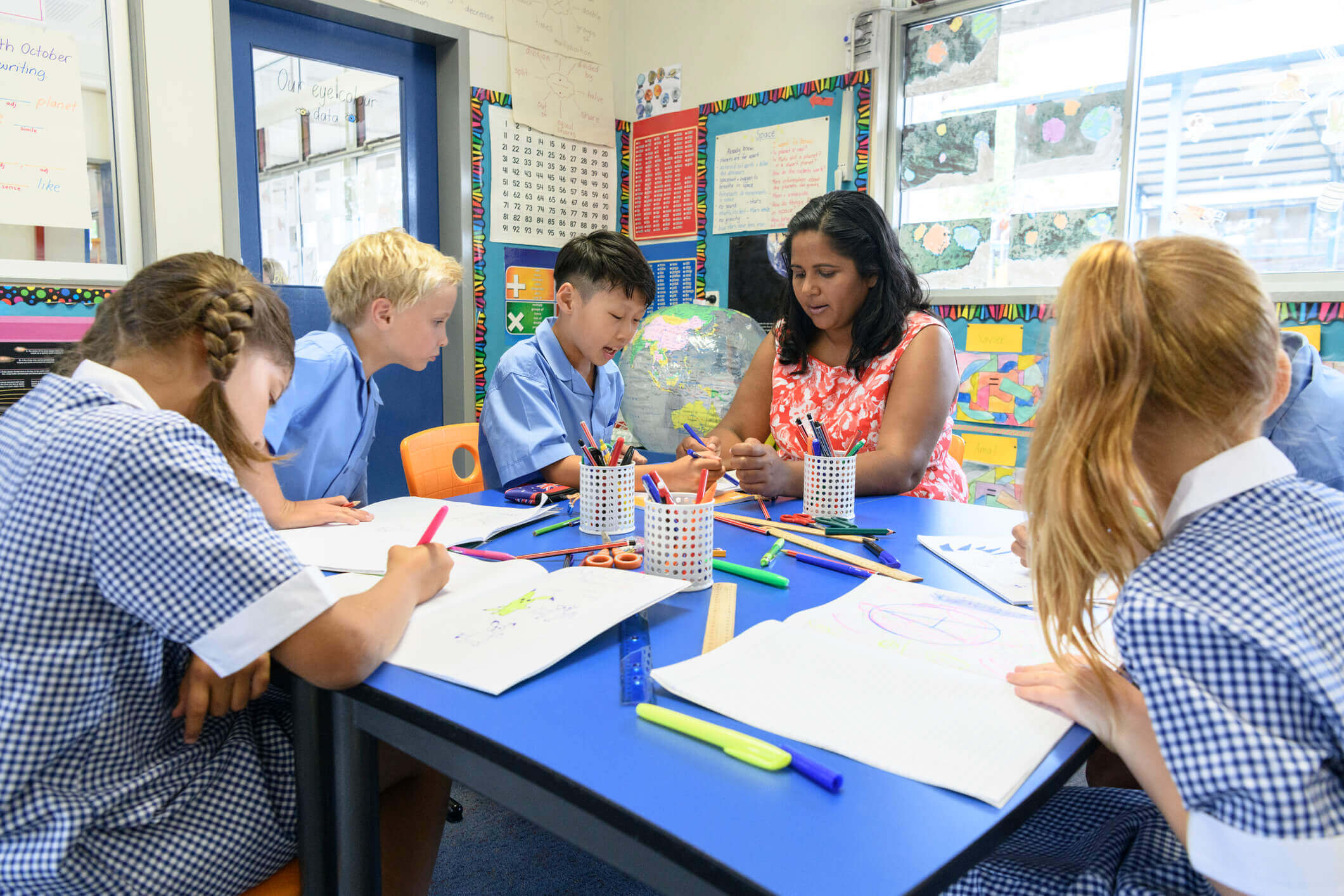 classroom students working on an art project with the teacher
