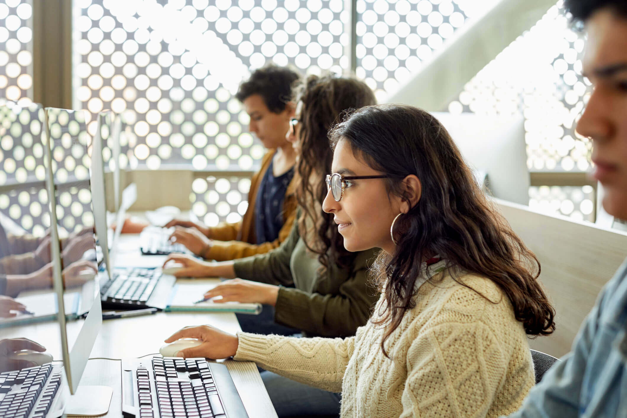 Young female student studying on a computer in a classroom.
